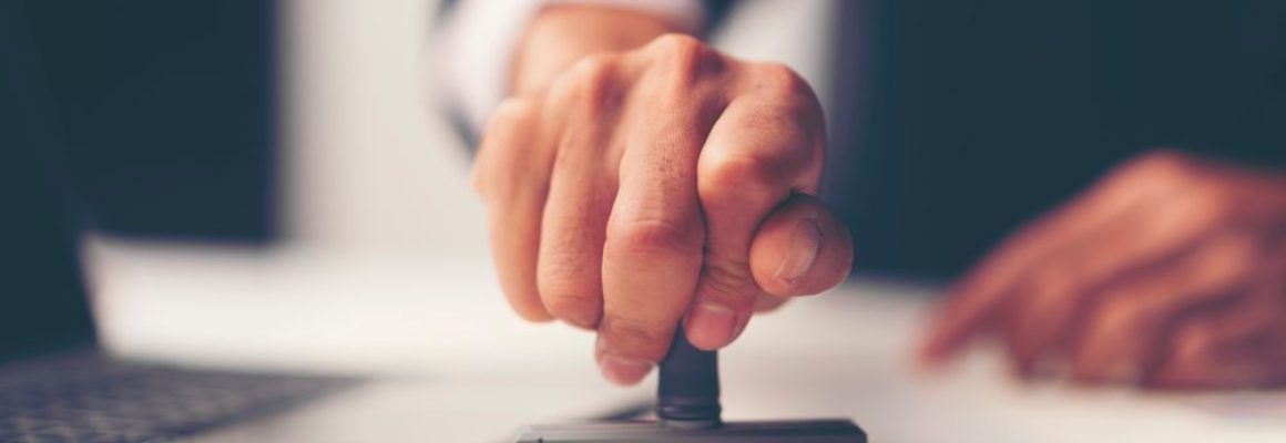 man drukt stempel op papier