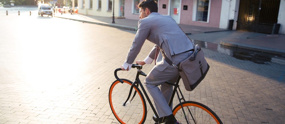 man in pak op de fiets