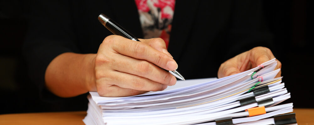 stapel papiere, vrouw met pen in hand