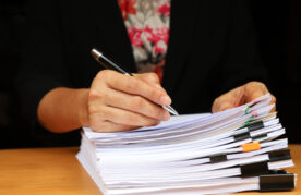 stapel papiere, vrouw met pen in hand