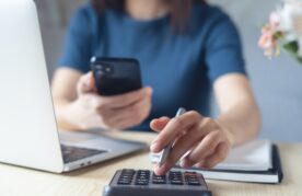 vrouw met telefoon en rekenmachine